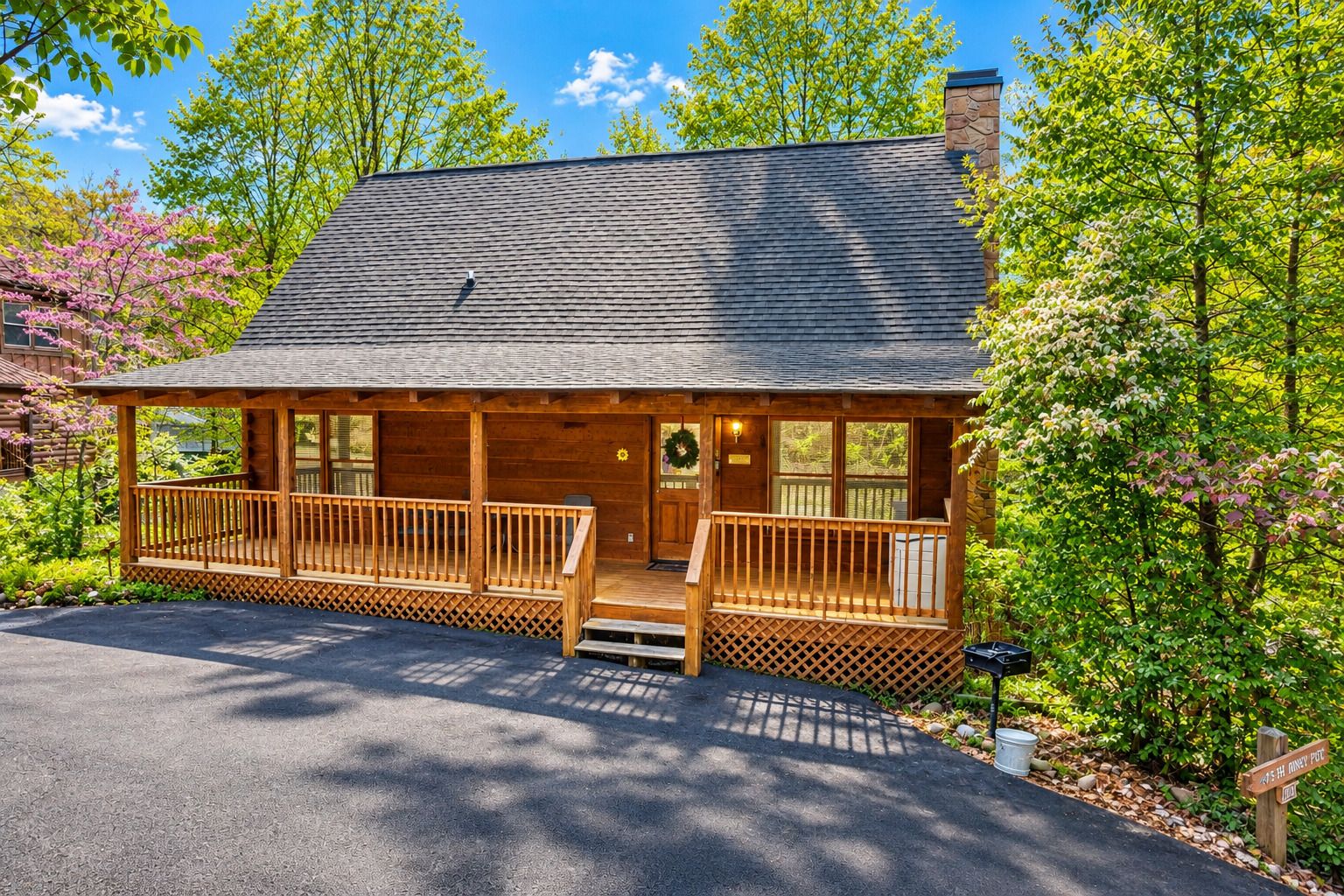 Een huisje met een veranda, schoorsteen en een krans bij de deur.