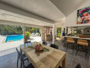 Espaçosa sala de jantar com vista para uma piscina e área de estar externa.