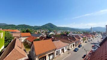 A town with red-tiled roofs, a main street, and a mountain in the background.