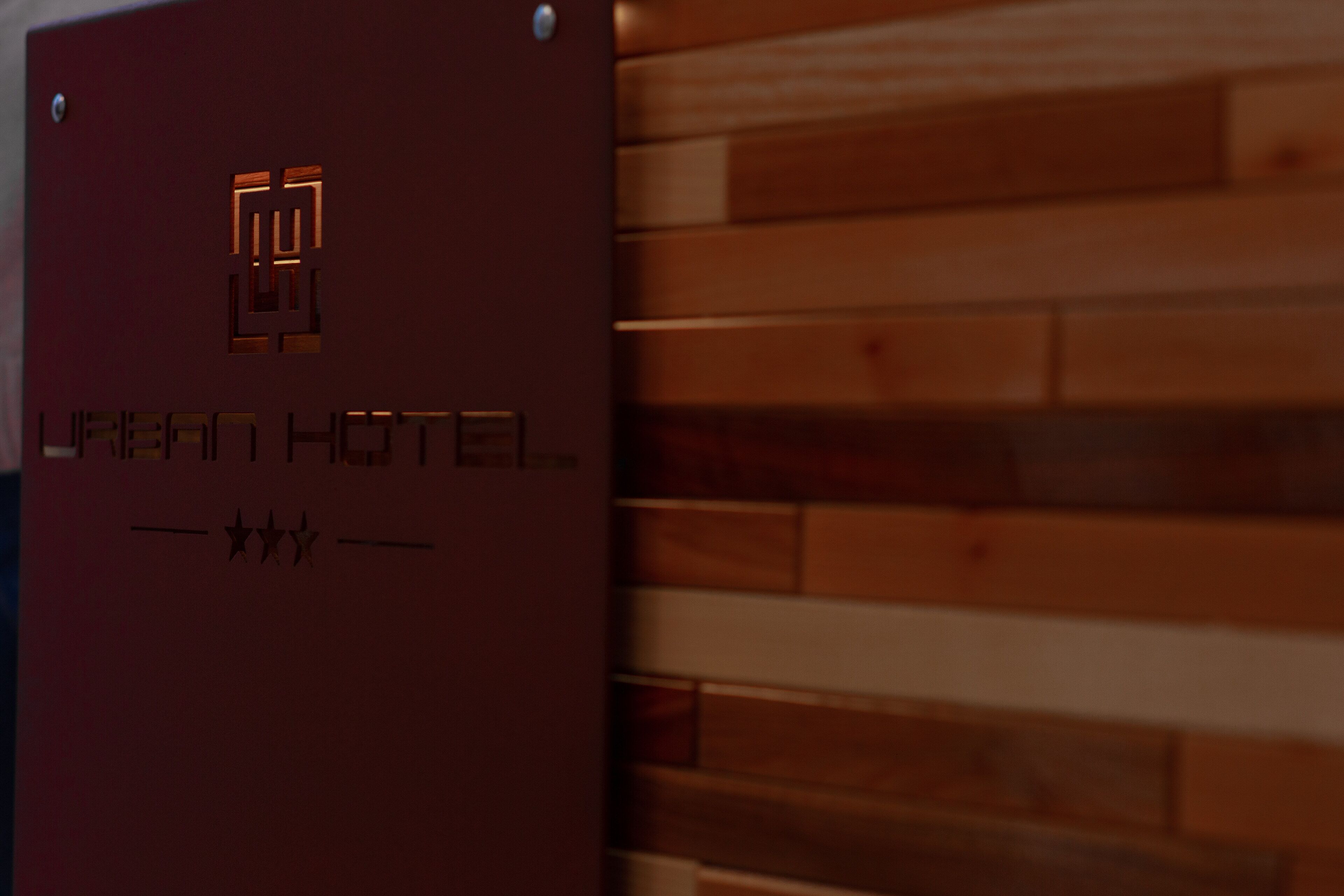 Eine Holzwand mit einem Schild, auf dem ‘Urban Hotel’ steht.