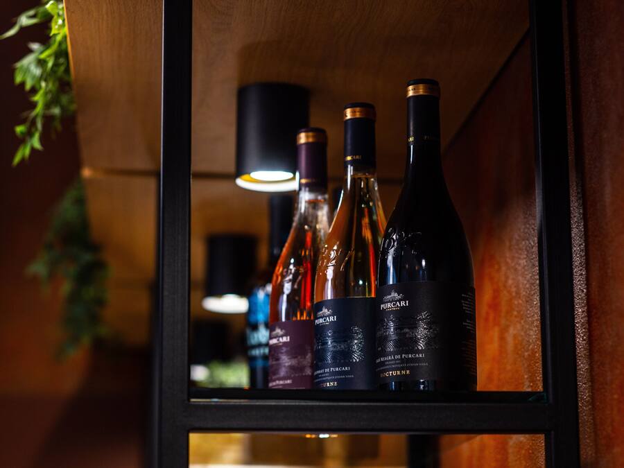Una botellera con varias botellas de vino, incluyendo una botella etiquetada 'Purocari'.