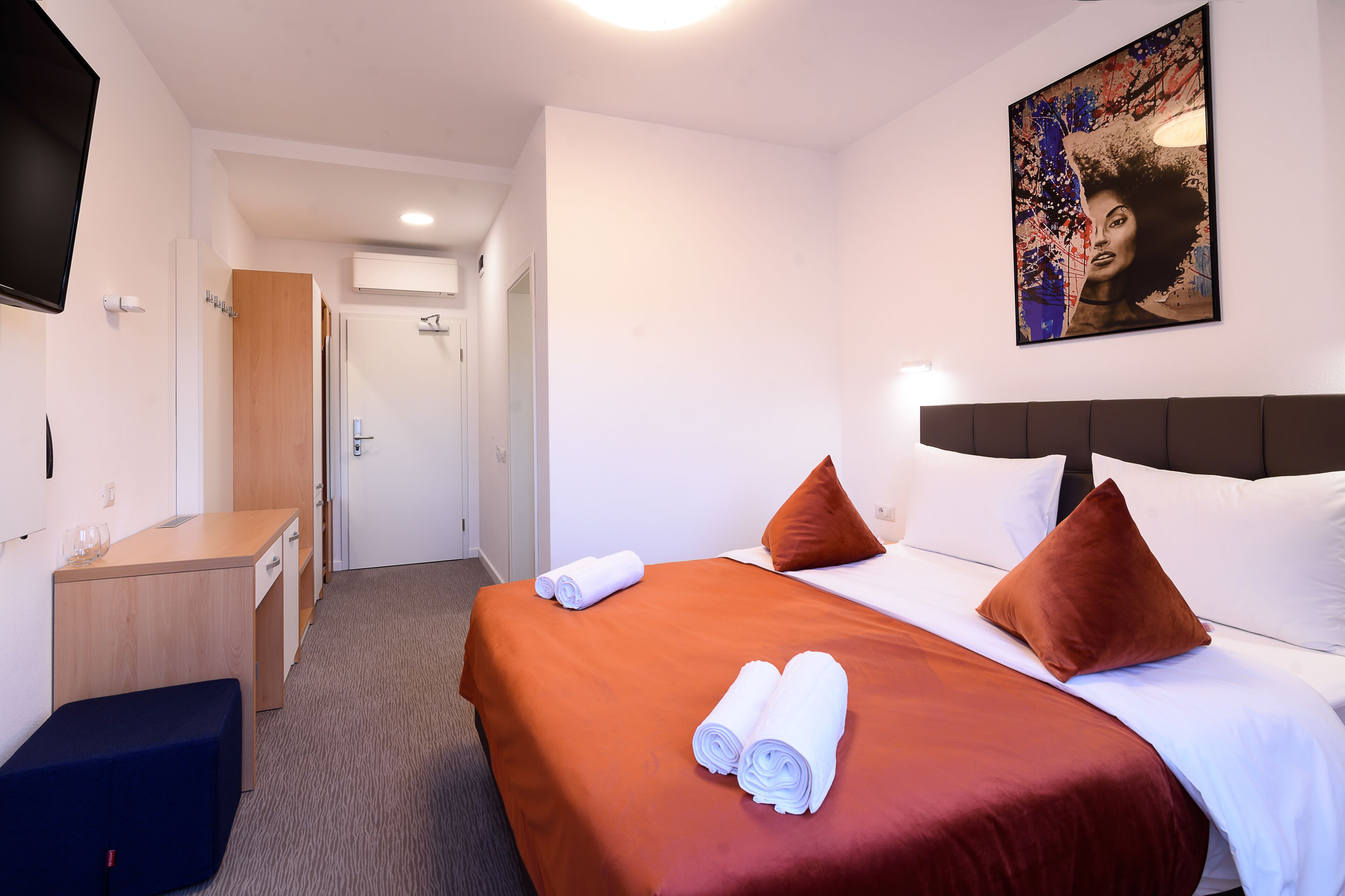 Una habitación de hotel con una cama, un escritorio y un televisor.