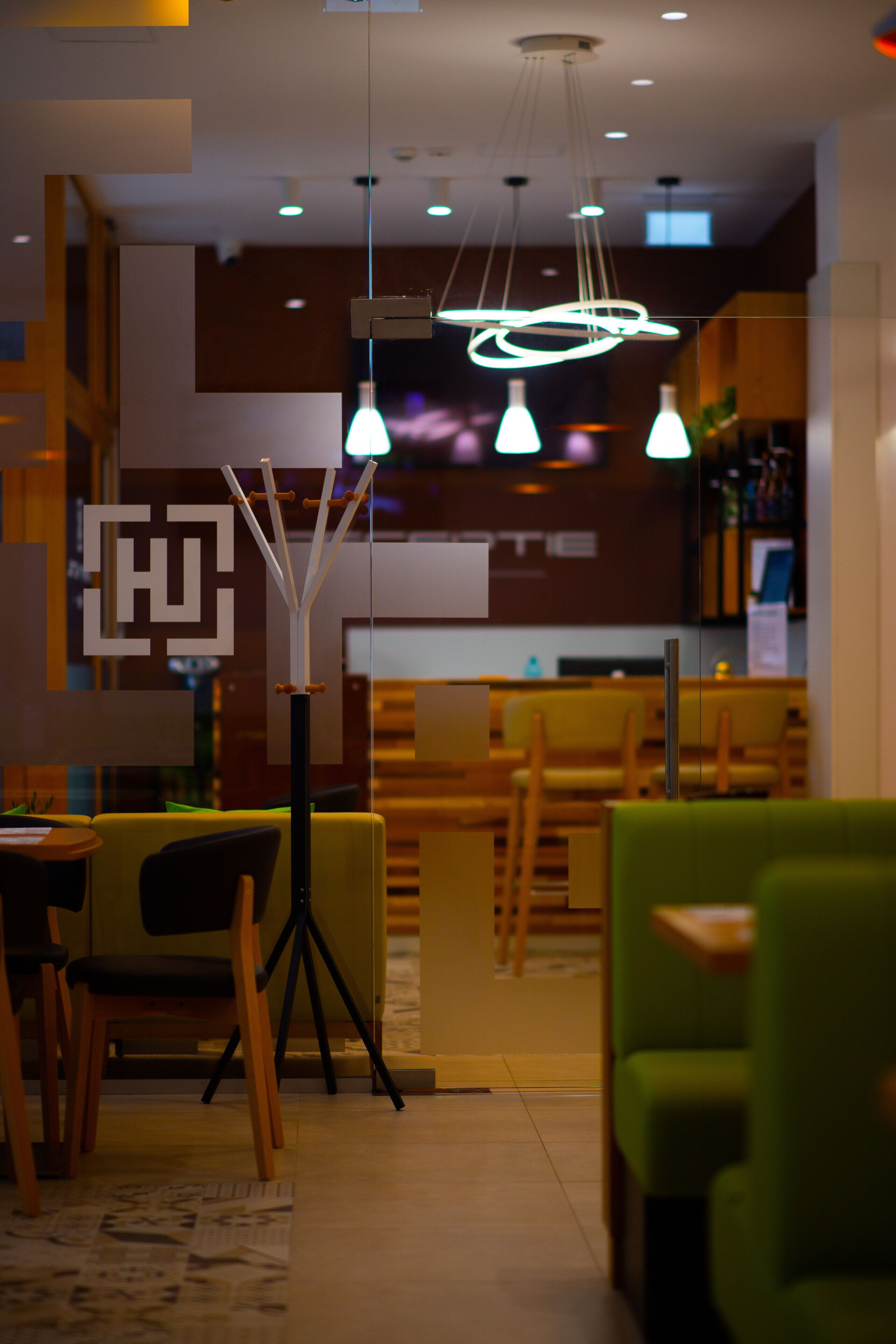 A modern interior with a dining area, a bar, and a reception desk.
