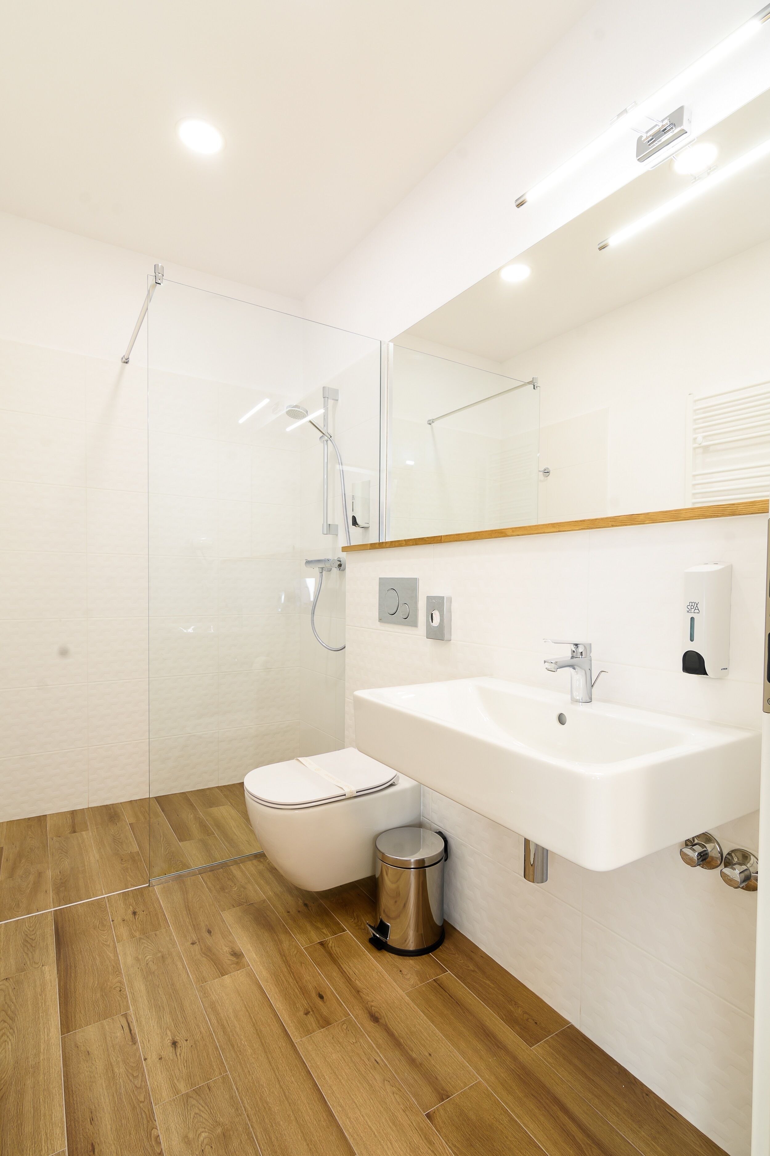 A modern bathroom with a shower, toilet, and sink.