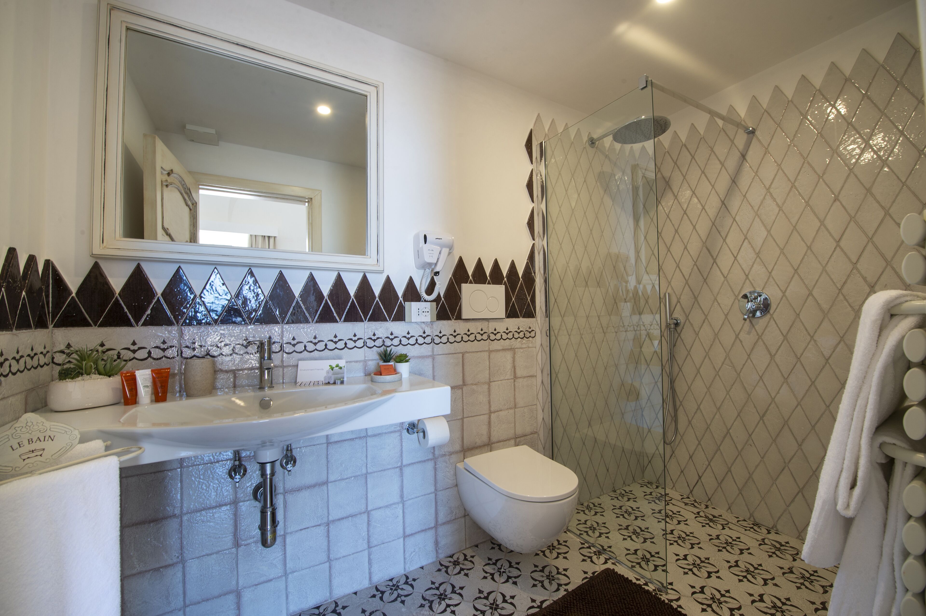 A bathroom with a sink, toilet, and shower area.