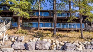 Un edificio a più piani con facciata in legno, ampie finestre e una scalinata in pietra che conduce all'ingresso.