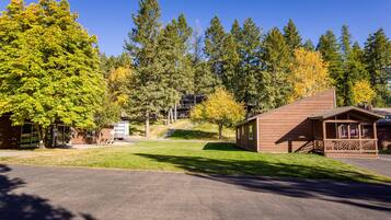 A lodge with a wooden exterior, a covered porch, and a parking area.