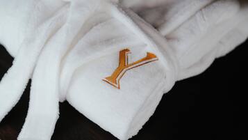 Una bata blanca con un logotipo bordado en oro.
