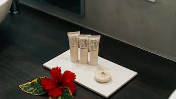 A white tray with four tubes of Roberto Cavalli body lotion and a small round container on a dark wooden surface.