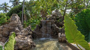 Une formation rocheuse naturelle avec une petite cascade et de l’eau claire.
