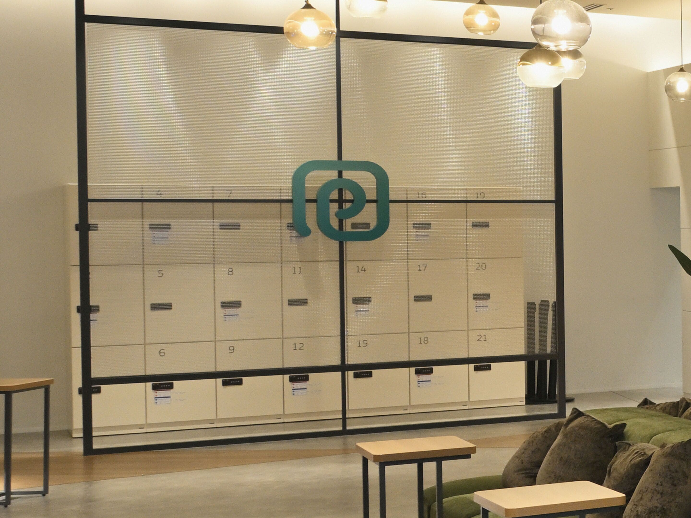 A modern office space with a large filing cabinet, a green couch, and a small table.