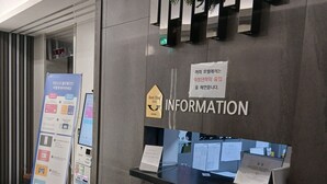 Un comptoir d’accueil avec une pancarte indiquant « RENSEIGNEMENTS » et un trophée « Meilleur hôtel de 2024 ». On y trouve également un écran numérique affichant des informations et une affiche fixée au mur.