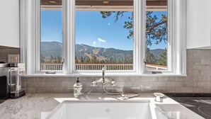 Une salle de bain dotée d’une grande fenêtre donnant sur les montagnes.