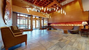 A spacious lobby with large windows, a high ceiling, and modern lighting fixtures. - Pet-Friendly in Luxury Hotel. Across The Village, EV Charging Station On-site (Mammoth Lakes)