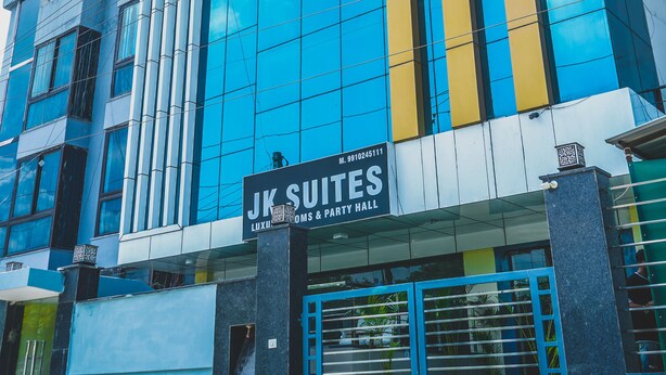 A modern building with a sign for "JK SUITES LUXURY COVERS & PARTY HALL". - JK Suites (Gurugram)