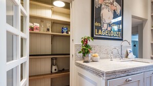 A kitchen with a marble countertop, a sink, a blender, and a potted plant. - Notting Hill Townhouse - by Out of Office Lifestyle (London)