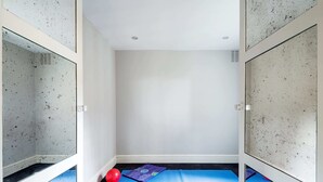 A small, empty room with a blue mat and a red ball on the floor. - Notting Hill Townhouse - by Out of Office Lifestyle (London)
