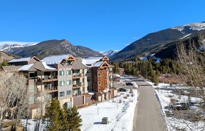 A multi-story hotel with a modern design, featuring balconies and large windows. - Modern Keystone Condo | Lake Fun + Hot Tubs (Keystone)