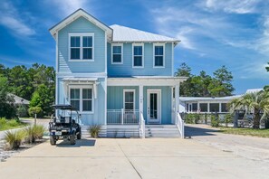 Une maison à deux étages avec un porche, un garage et une allée.
