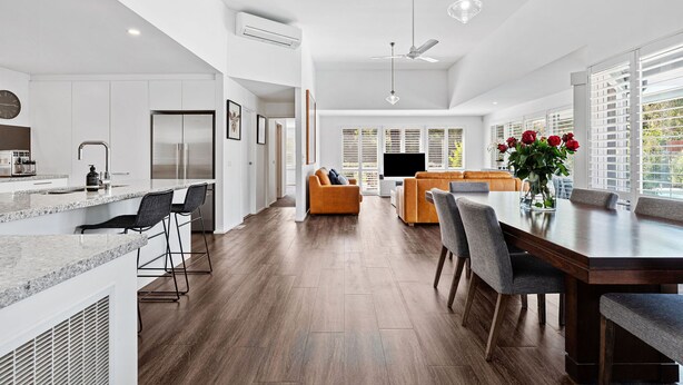 A modern kitchen with a built-in oven and a dining area with a wooden table and chairs. - Hamptons Resort: 3  BR, 2  BA House in Sorrento, Sleeps 6 (Sorrento)