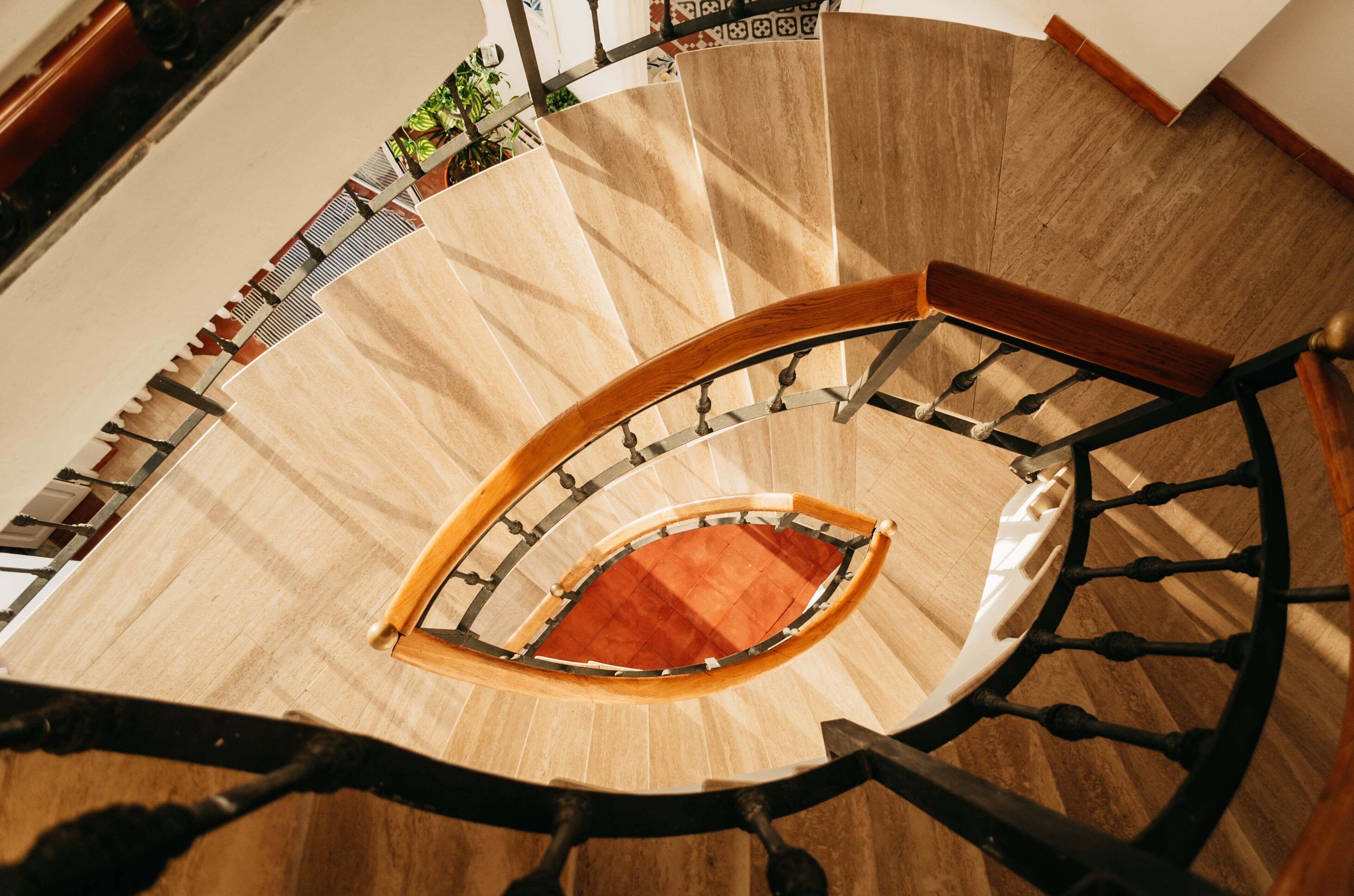 Un escalier en colimaçon avec des marches en bois et des rampes en métal.