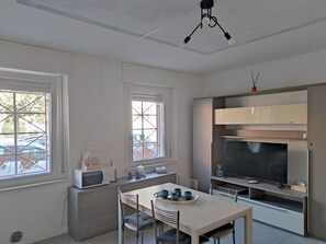 Eine moderne Küche mit Essbereich, integriertem Mikrowellenherd und einem großen Fernseher.