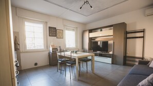Eine moderne Küche mit Essbereich, Fernseher und eingebautem Backofen.