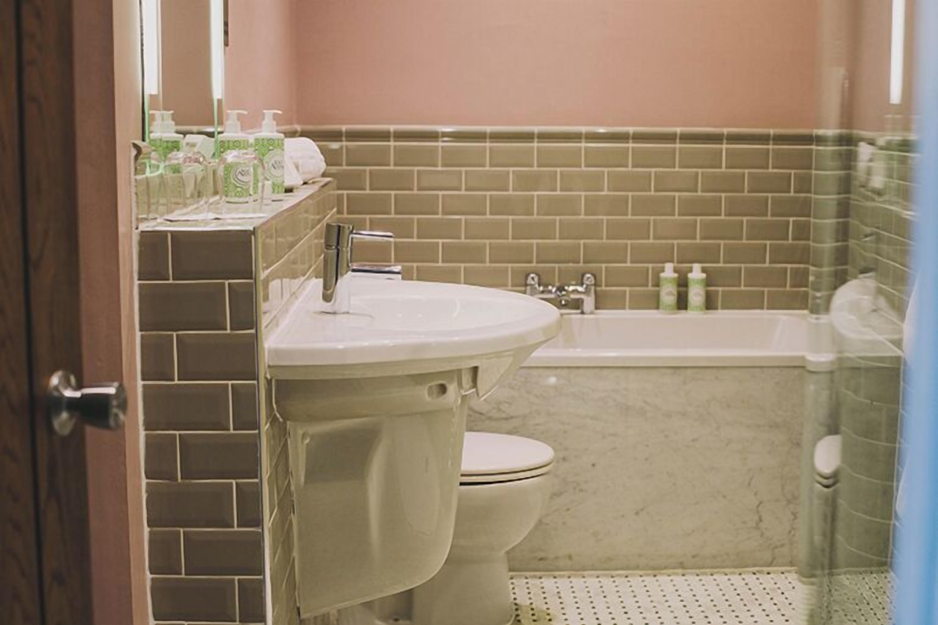 A bathroom with a toilet, sink, and bathtub.