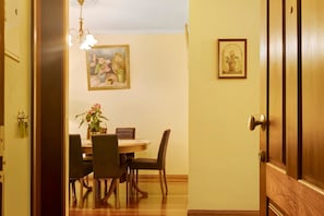 A dining area with a wooden table, chairs, and a chandelier.