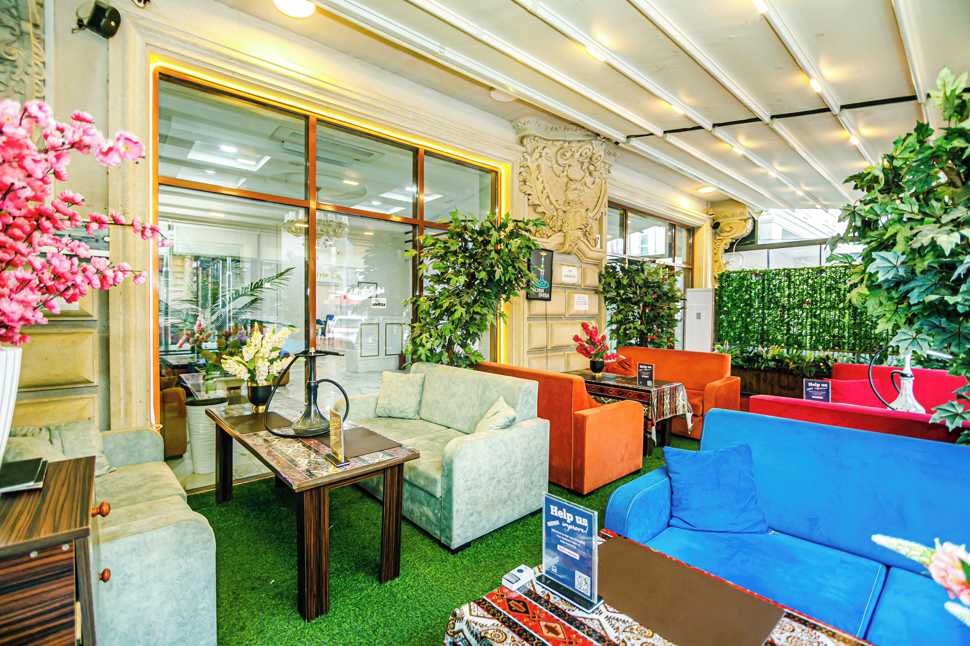 A furniture showroom with various sofas, a table, and decorative plants.