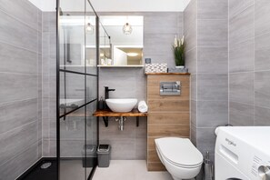 Chuveiro, toalhas de banho, sabonete, shampoo