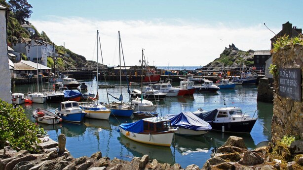 A harbor with various boats docked, a rocky shoreline, and a sign warning against feeding birds. - Rowan Retreat - One Bedroom Cottage, Sleeps 2 (Lanreath)