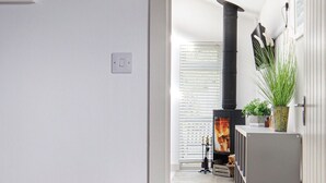 Una sala de estar moderna con chimenea, un banco de madera y una planta en maceta.