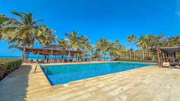 Una piscina al aire libre, sillones reclinables de piscina