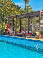 Una piscina al aire libre, sillones reclinables de piscina