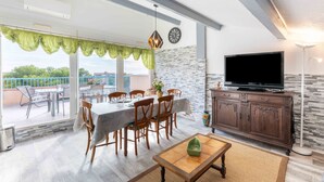 Un comedor con mesa, sillas, un televisor y un mueble.