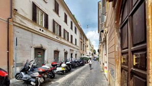 A cobblestone street lined with parked motorcycles and historic buildings. - 4bnb - Ombrellari 4 (Rome)