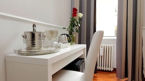 A white desk with a tray, a kettle, a vase with flowers, and a chair. - 4bnb - Otranto Vatican Apartment (Rome)
