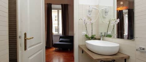 A modern bathroom with a white sink, a mirror, and a hairdryer.