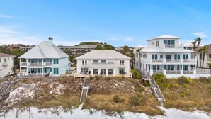 A beachfront property with multiple houses, including a large white house with a balcony and a smaller blue house with a covered deck. - Spectacular Gulf Front 30A! Private Pool & Gulf Views, Fall Specials! (Santa Rosa Beach)