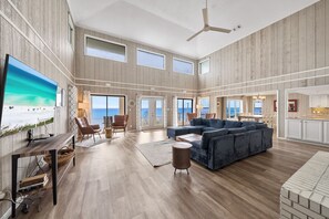 A spacious living room with a large sectional sofa, a TV mounted on the wall, and a ceiling fan. - Spectacular Gulf Front 30A! Private Pool & Gulf Views, Fall Specials! (Santa Rosa Beach)