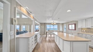 A spacious kitchen with white cabinetry, a large island, and a view to the outside. - Spectacular Gulf Front 30A! Private Pool & Gulf Views, Fall Specials! (Santa Rosa Beach)