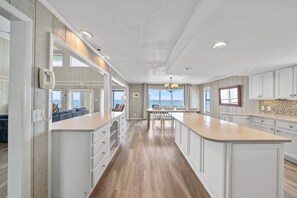 A spacious kitchen with white cabinetry, a large island, and a view to the outside. - Spectacular Gulf Front 30A! Private Pool & Gulf Views, Fall Specials! (Santa Rosa Beach)