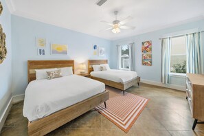 A hotel room with two beds, a ceiling fan, artwork on the walls, and a view through the window. - 30A Paradise! Pool, Tiki Bar & 6-Seat Golf Cart 5-Bed Book Now for Fall! (Santa Rosa Beach)