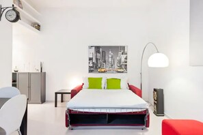 A modern bedroom with a bed, a desk, a chair, and a cityscape painting on the wall. - 4bnb - Giulio Cesare Cozy Apartment (Rome)