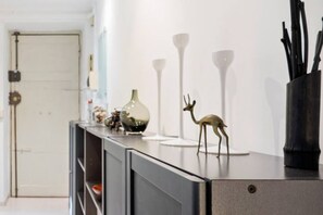 Kitchen area with a sleek countertop, decorative vase, and metallic figurine.