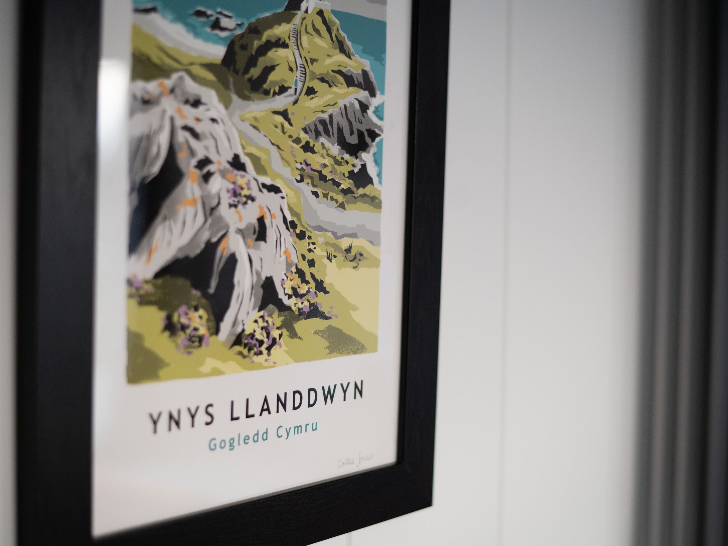 A framed artwork with a mountainous landscape and text.