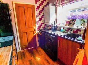 Enjoy cooking in this well-equipped kitchen with a sink, kettle, and ample counter space.