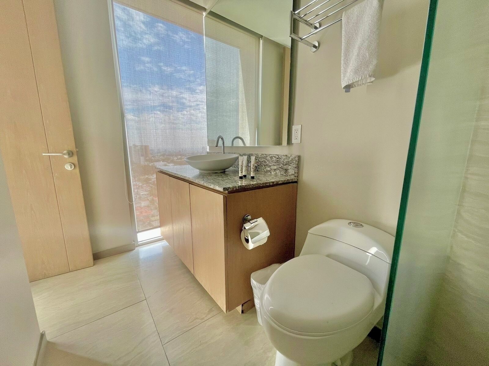 A modern bathroom with a toilet, sink, and mirror.