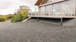 A modern house with a wooden exterior and a glass balcony. - The Lodge (Stranraer)